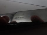 a person holding a knife in their hand on a table