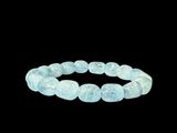un gros plan d'un bracelet avec des perles bleues sur fond noir