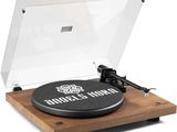 un gros plan d'un tourne-disque posé sur une surface en bois