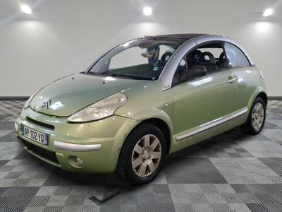 a small green car parked in a room with checkered floor