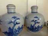 two blue and white vases sitting on a shelf
