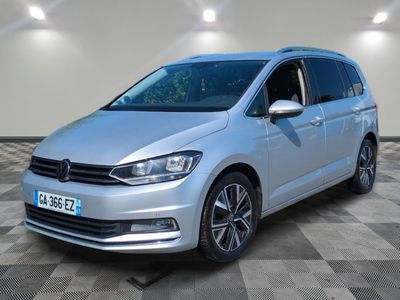 une VW Tourer argentée garée dans une pièce au sol à carreaux
