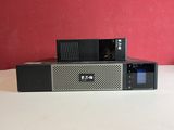 une photo d'un micro-ondes noir et argent posé sur une table blanche