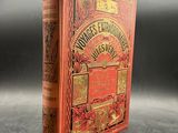 a red book with gold lettering on it sitting on a table