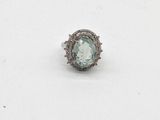 une bague ovale sertie d'une aigue-marine et de diamants, posée sur un fond blanc