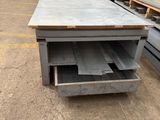 an industrial steel table with a drawer in the middle of it