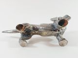 a silver dog figurine on a white surface