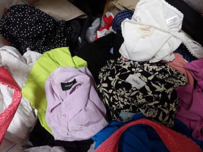 a pile of clothes that is sitting on a bed