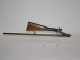 an old gun with a wooden barrel on a clear stand