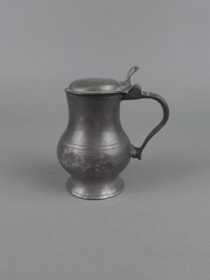 une chope ancienne en métal argenté, munie d'une anse et d'une poignée