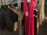 un présentoir dans un magasin de vêtements, avec des vêtements suspendus à des cintres