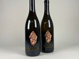 two bottles of wine sitting next to each other on a table
