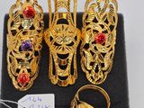 six pairs of gold rings and bracelets on a black display case