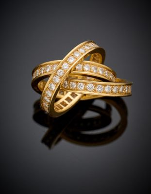 gros plan d'une bague en or avec des diamants sur une surface noire