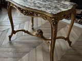 a marble topped table in the middle of a living room