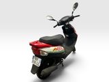 a scooter that is red and white with a black seat