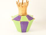 a gold crown sitting on top of a green and purple container