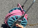 un chariot à tuyaux bleu et rose posé par terre