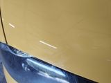 a close up of a car ' s front bumper with a denting on it