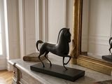 a statue of a horse standing on a marble table