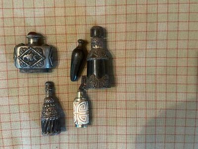 trois figurines en argent posées sur une nappe à carreaux