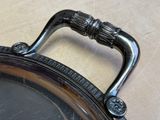 a silver plate with a handle on a table