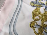 a close up of a scarf with a gold and blue design