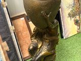 un vase en bronze posé sur un tapis vert
