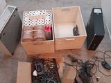deux cartons contenant du matériel électronique, posés par terre l'un à côté de l'autre