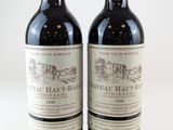 deux bouteilles de vin rouge posées l'une à côté de l'autre sur une surface blanche