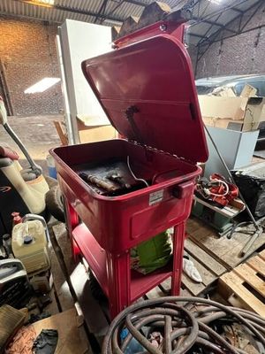 une glacière rouge posée sur une palette dans un garage