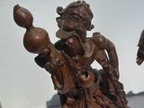 pair of wooden figurines of a man and a woman on a boat