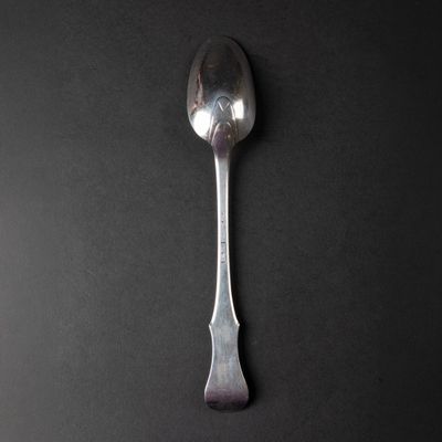 silver spoon on a black table with a black background