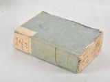 an old book sitting on a table with a tag on it