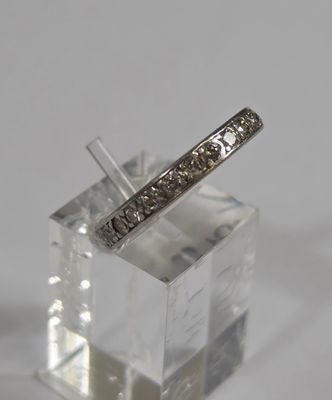 an image of a diamond wedding band on a clear block