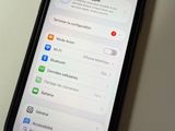 an iphone with the settings displayed on the screen is plugged into a charger