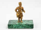 bronze figurine of a man holding a pot on a green marble base