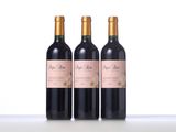 three bottles of wine sitting on top of a white table