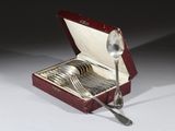 des couverts dans une boîte rouge, avec une cuillère et un repose-cuillère