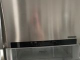 a stainless steel refrigerator with its door open in a kitchen
