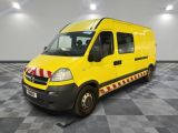 La camionnette jaune est garée sur le sol à damier du garage.