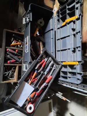 de nombreux outils dans une boîte à outils posée par terre