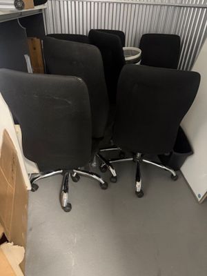 three black office chairs sitting in a room with cardboard boxes on the floor