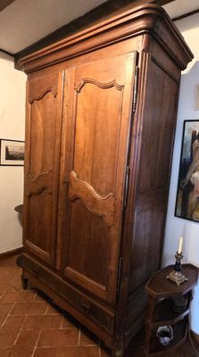 une grande armoire en bois dans le coin d'une pièce