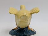 a yellow and black figurine of a giraffe on a blue base
