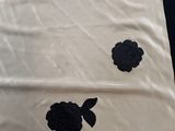 a white sheet with black flowers on it sitting on a table
