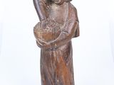 an old wooden statue of a woman holding a basket of flowers