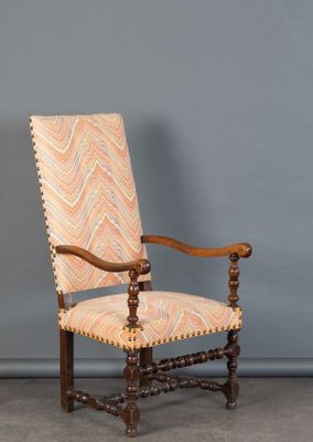 une vieille chaise en bois dont l'assise est recouverte d'un tissu à motifs