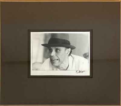 photographie en noir et blanc d'un homme portant un chapeau, dans un cadre