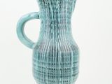 a blue vase that is sitting on a white surface